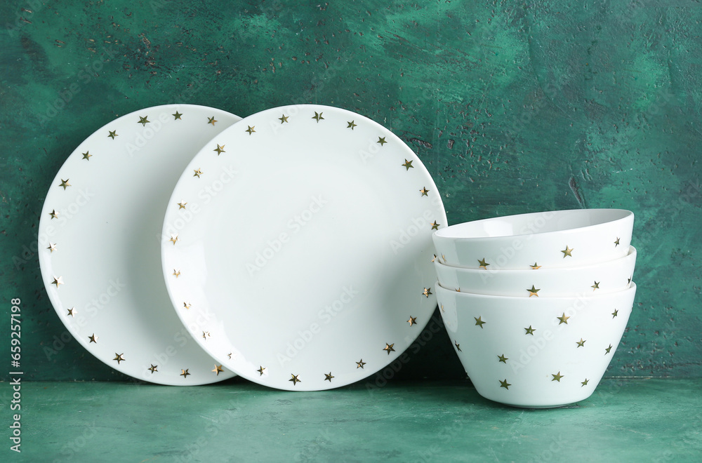 White plates and stack of bowls on green table