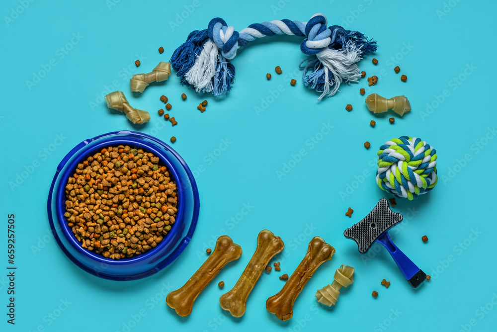 Frame made of different dog treats and pet care accessories on color background