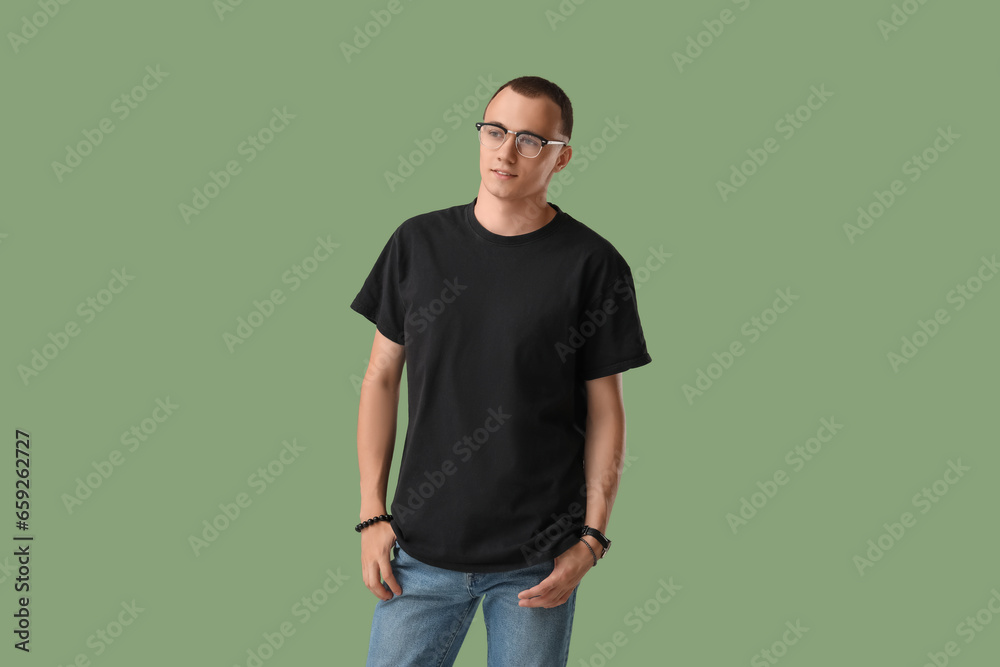 Handsome young man in black t-shirt on green background