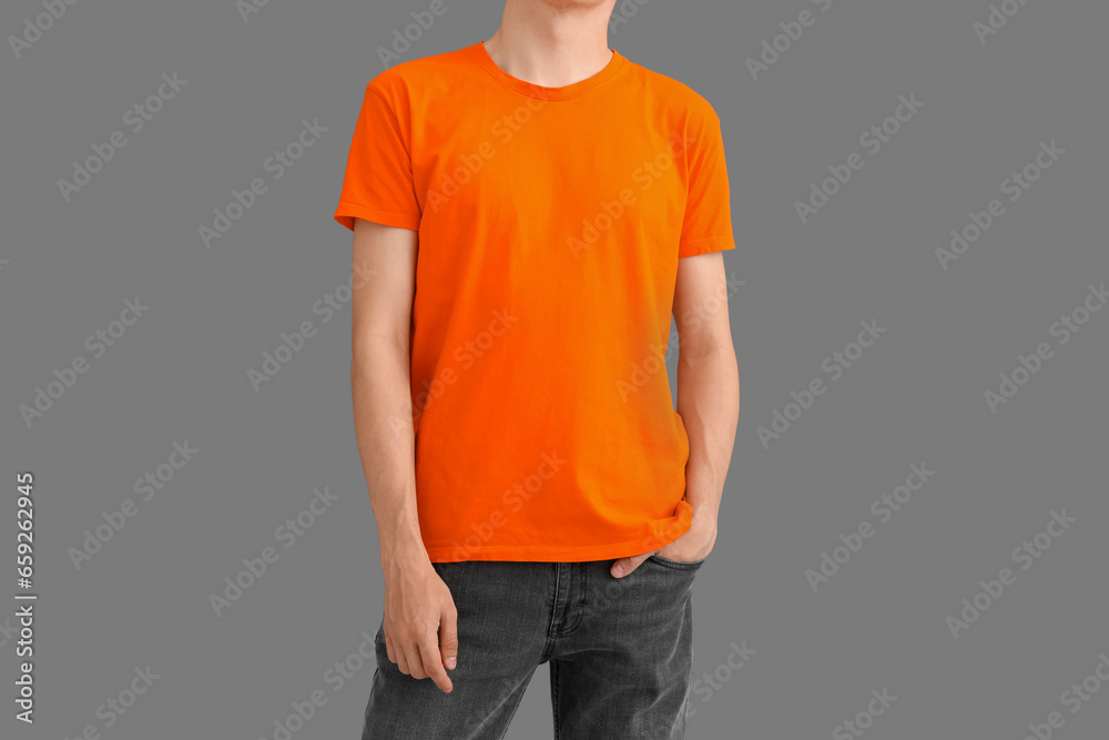 Man in stylish orange t-shirt on grey background