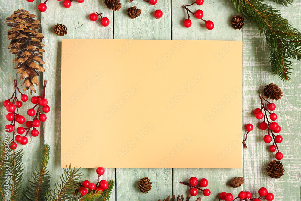 Beautiful Christmas composition with blank card, fir branches and berries on green wooden background