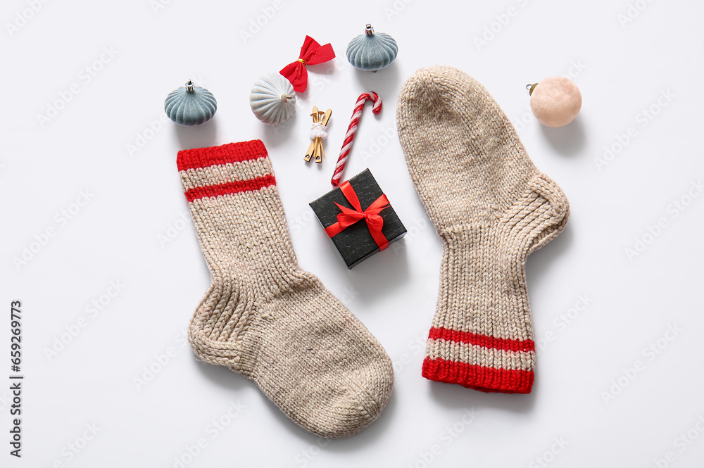 Christmas socks with beautiful decorations and gift box on white background