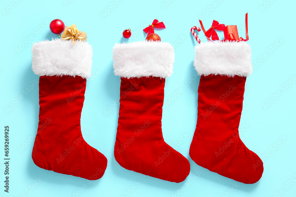 Christmas socks with bows, balls and gift boxes on blue background