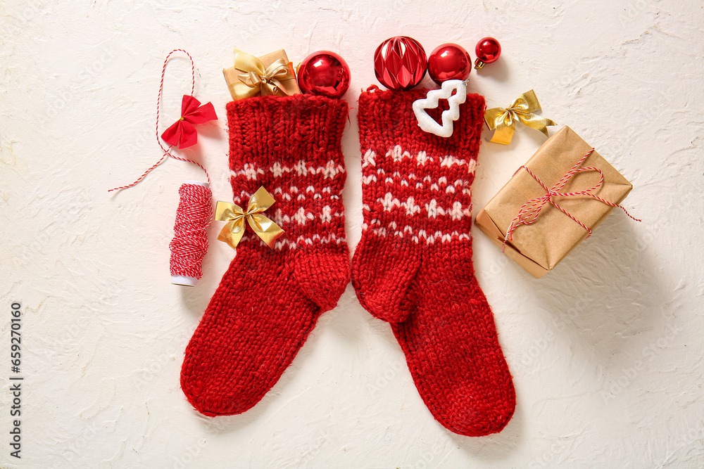 Christmas socks with balls, bows and gift boxes on white background