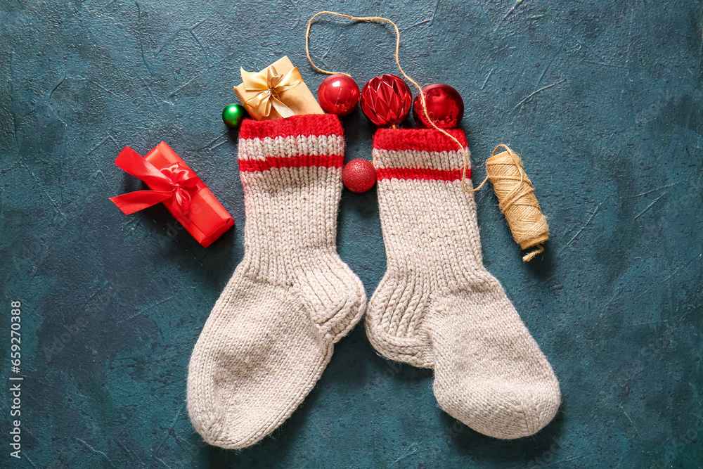 Christmas socks with balls and gift boxes on blue background