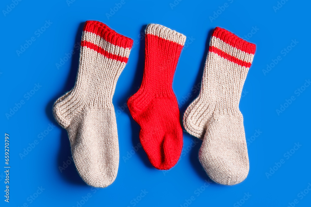 Different Christmas socks hanging on blue background