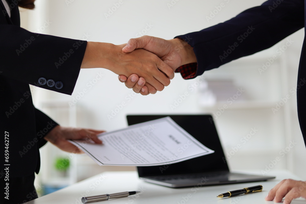 Business partners and colleagues shaking hands at work cooperation. Job applicant shaking hands with executives in office room at job interview.