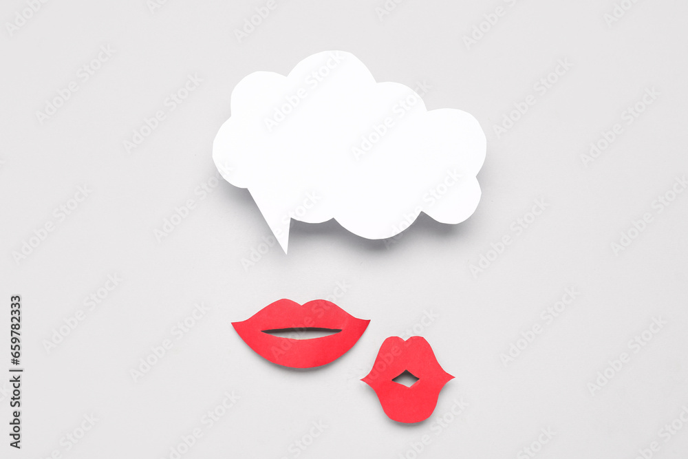 Paper lips with blank speech bubble on grey background