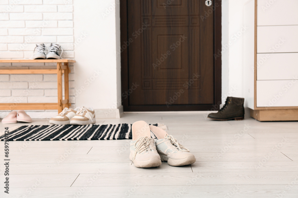 Stylish sneakers with orthopedic insoles on floor in room