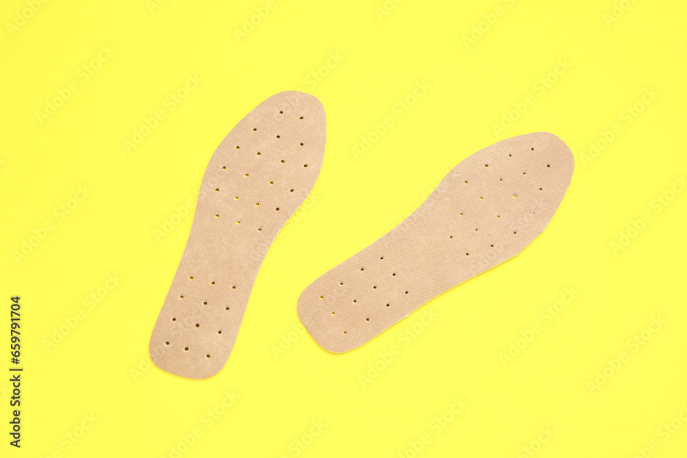 Orthopedic insoles on yellow background