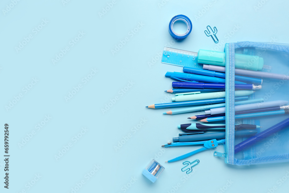 Stylish pencil case with different school stationery on blue background