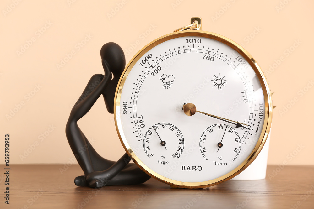 Aneroid barometer and decor on table in room, closeup