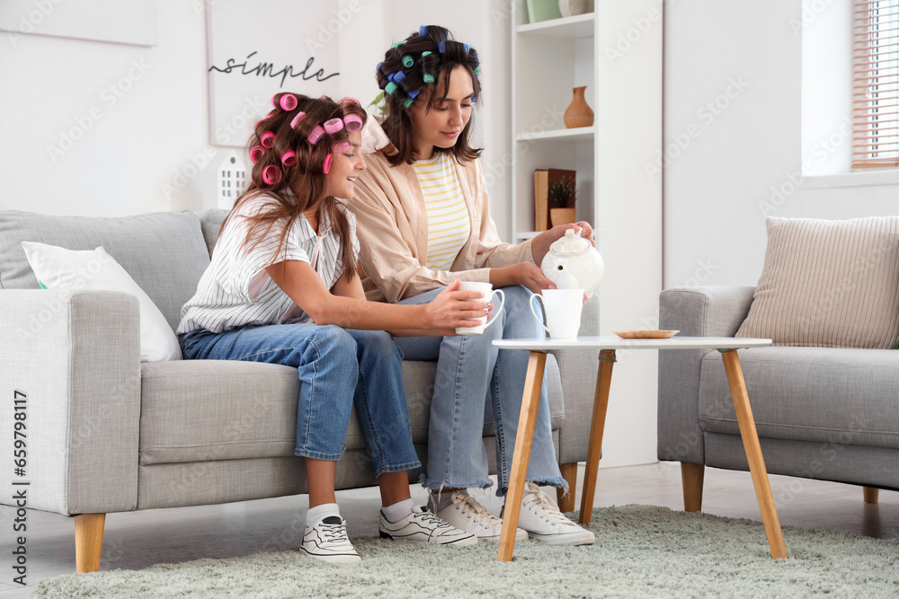 Little girl and her mother with hair curlers at home