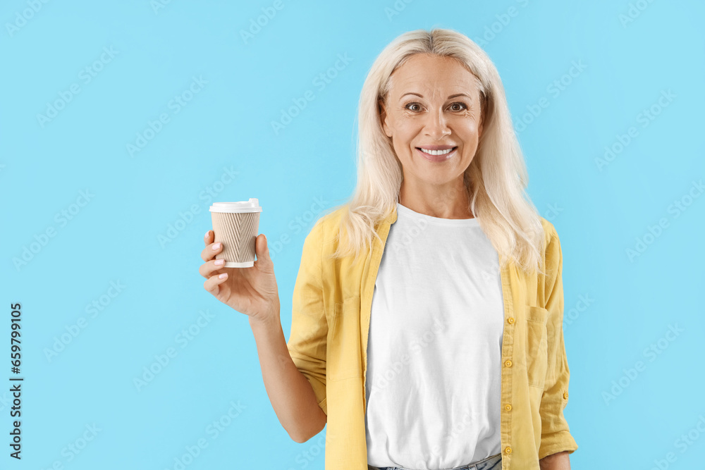 Mature woman with cup of coffee on blue background