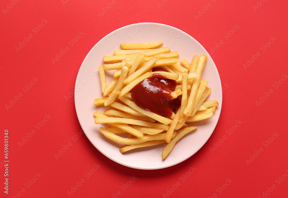 Plate with tasty french fries and ketchup on red background