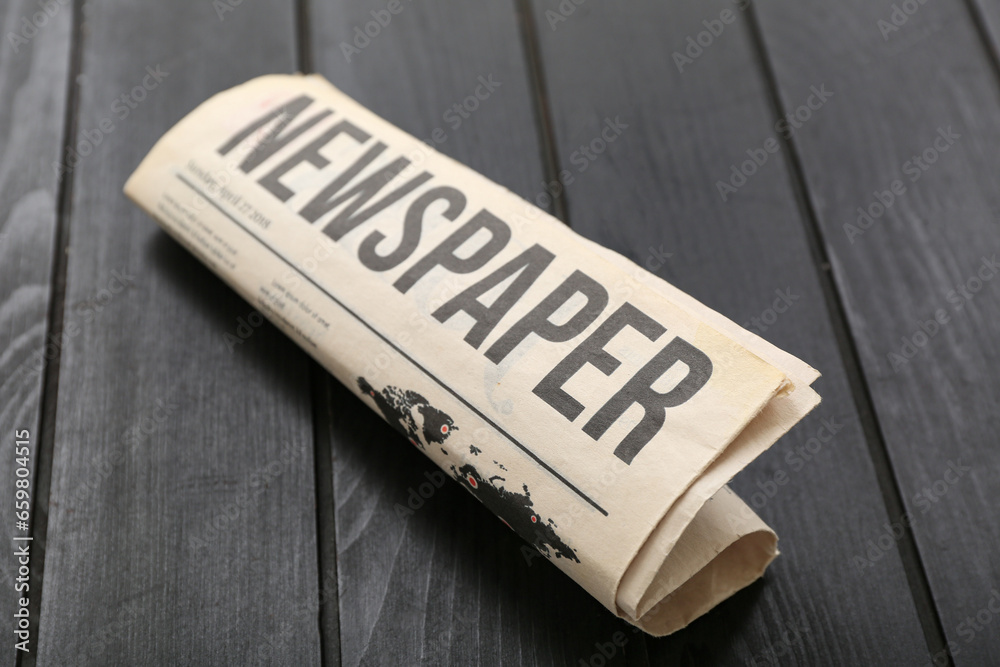 Morning newspaper on black wooden background