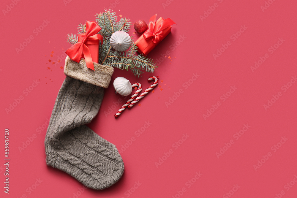 Beautiful Christmas sock with gift boxes and decorations on red background