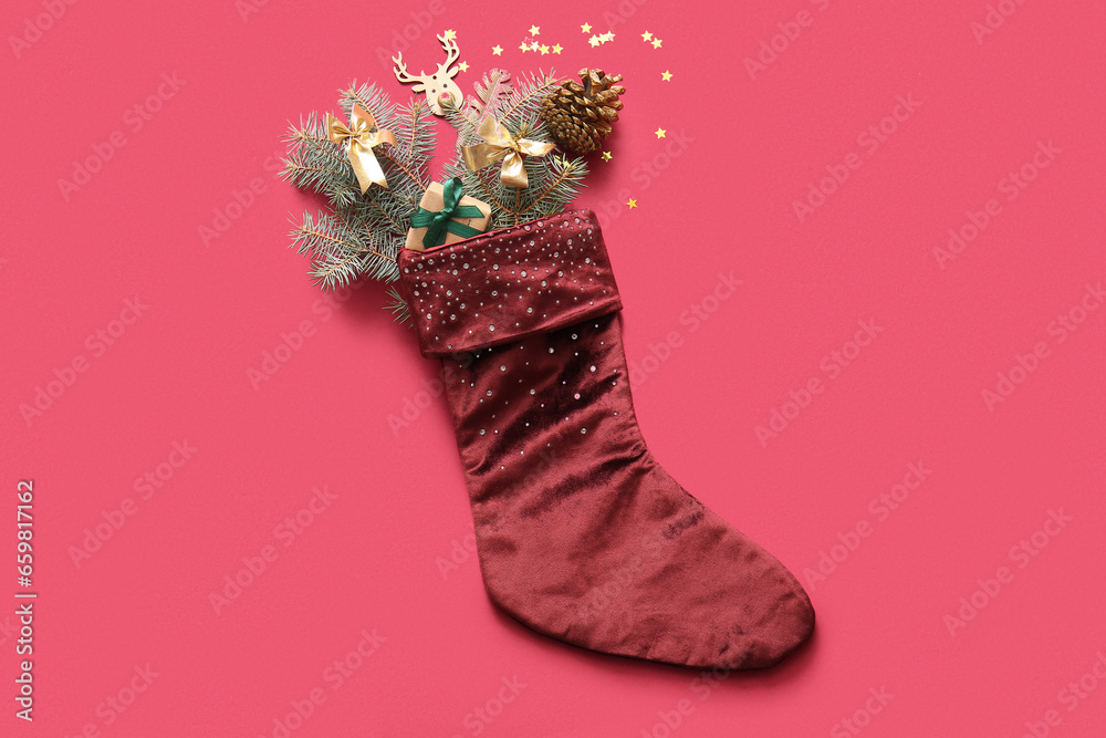 Beautiful Christmas sock with gift box and decorations on red background