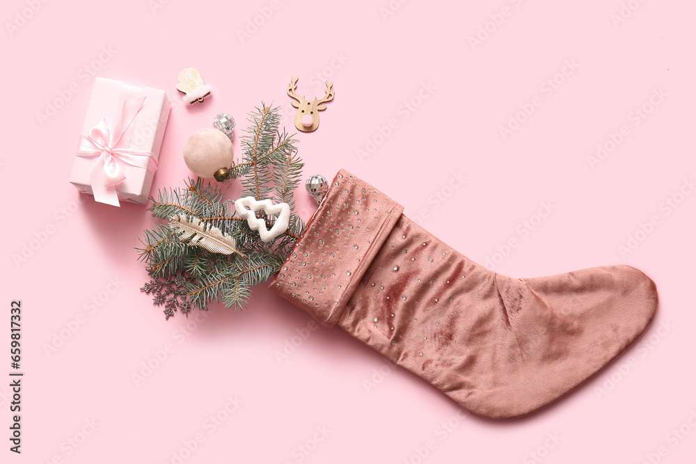 Beautiful Christmas sock with gift box and decorations on pink background