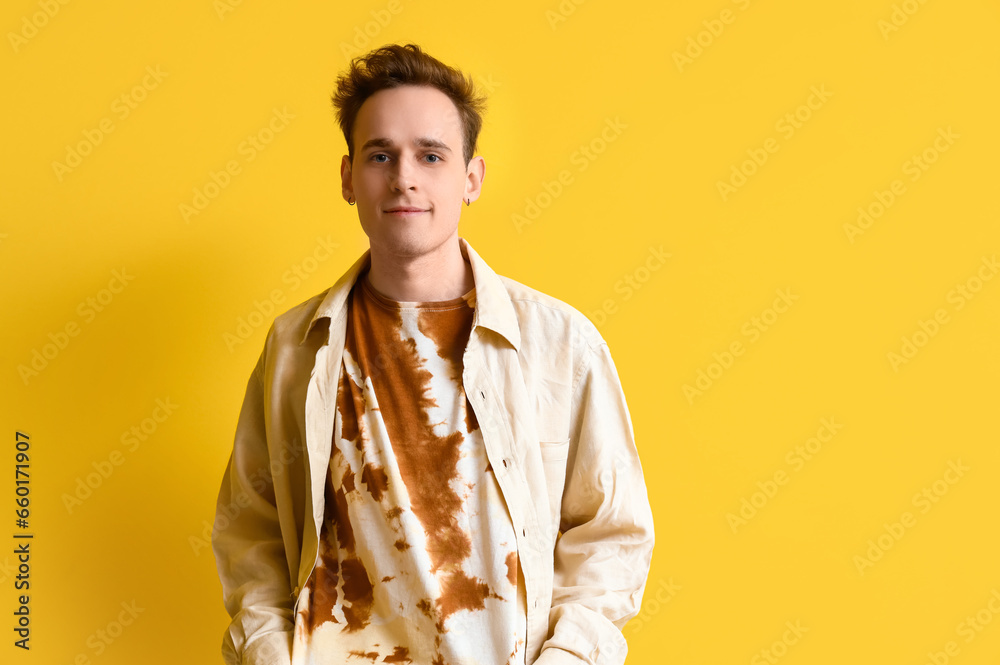 Young man in tie-dye t-shirt on yellow background