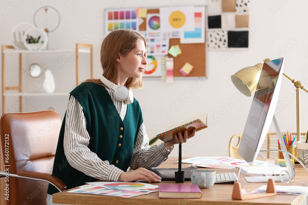 Female graphic designer working with computer at table in office