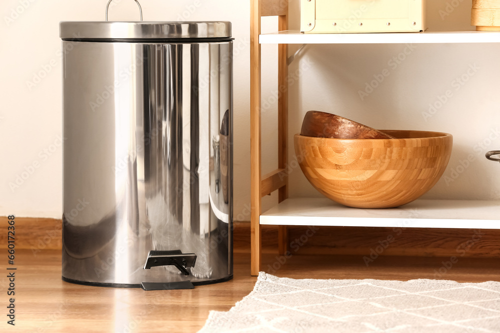 Metallic trash bin on floor in modern kitchen