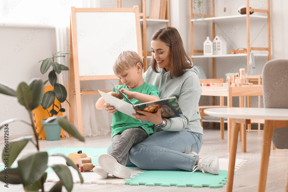 Nanny with little boy reading story at home