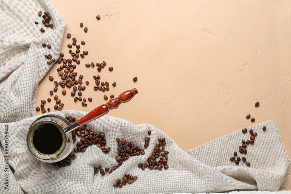 Cezve with coffee and scattered beans on beige background