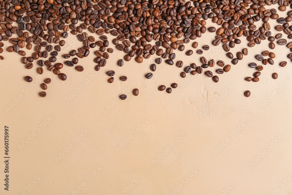 Scattered coffee beans on beige background