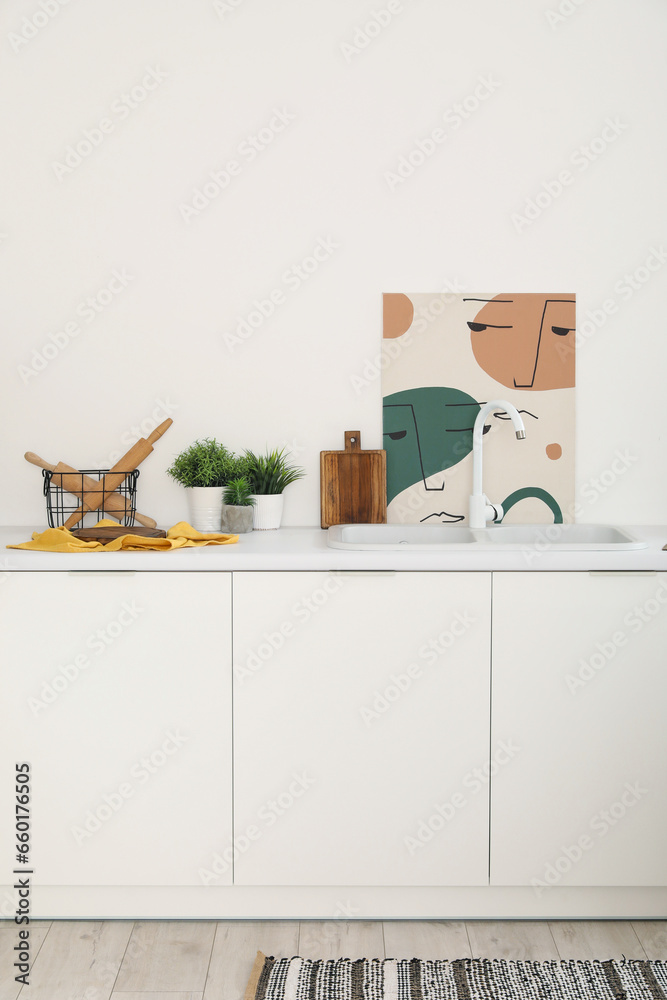 White kitchen countertop with sink, cutting board and rolling pins