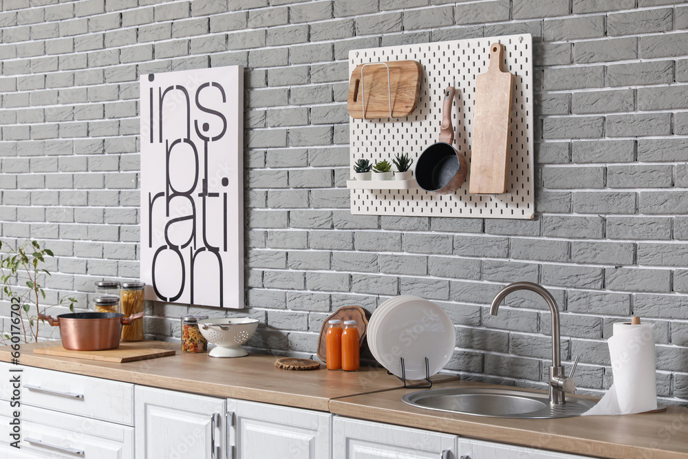 Sink, plate rack and utensils on white counters in modern kitchen