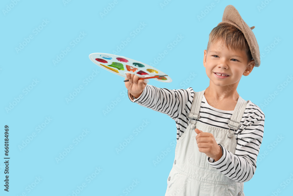 Cute little artist with paint palette on blue background