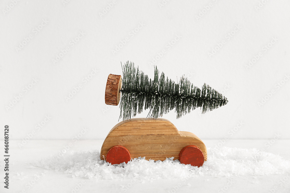 Wooden toy car with Christmas tree on white background