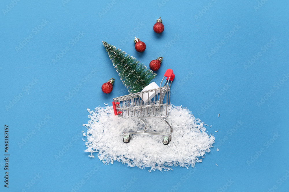 Shopping cart with Christmas tree and balls on blue background