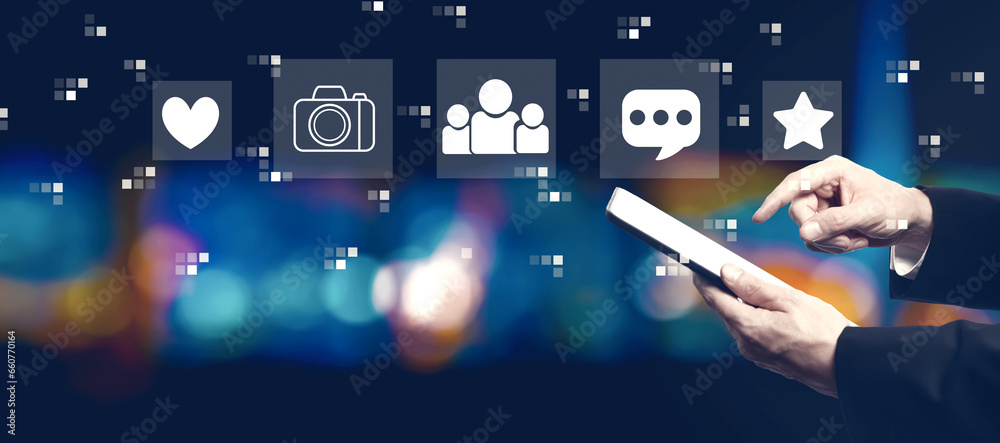 Social media theme with businessman using a tablet computer at night