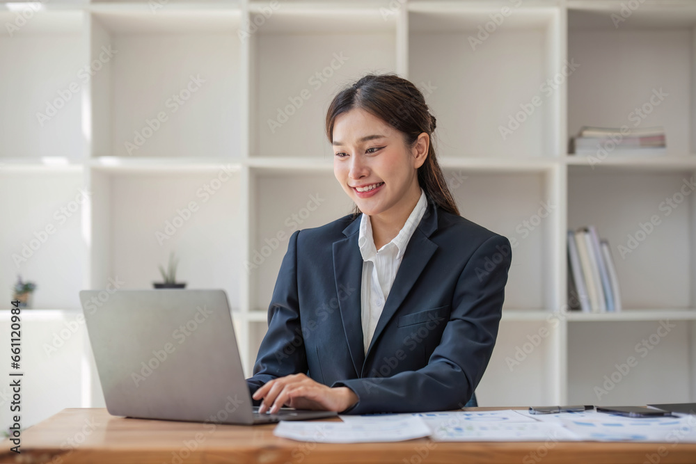 Asian businesswoman use laptop computer in office The Internal Revenue Service audit document balance calculation report is being prepared.