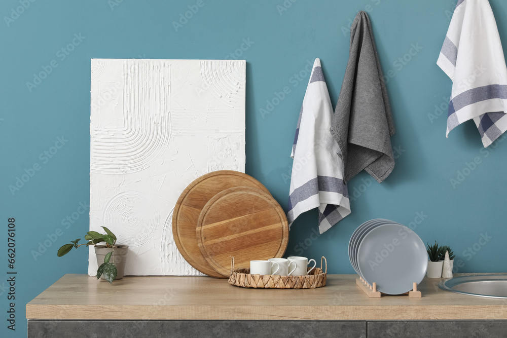 Grey kitchen counters with cutting boards, plate rack and utensils