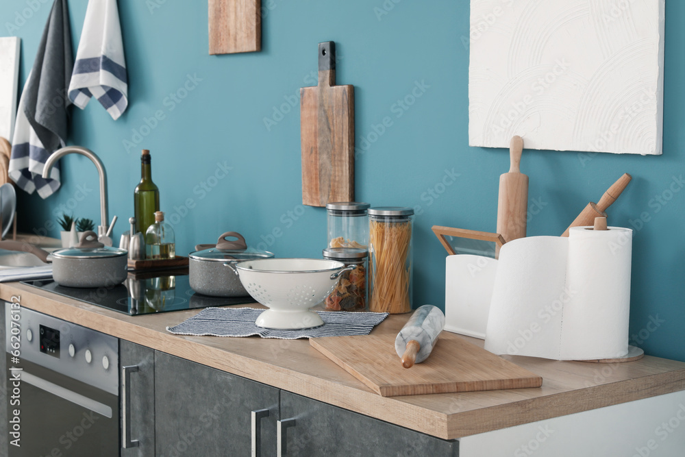 Grey kitchen counters with cutting boards, colander and utensils