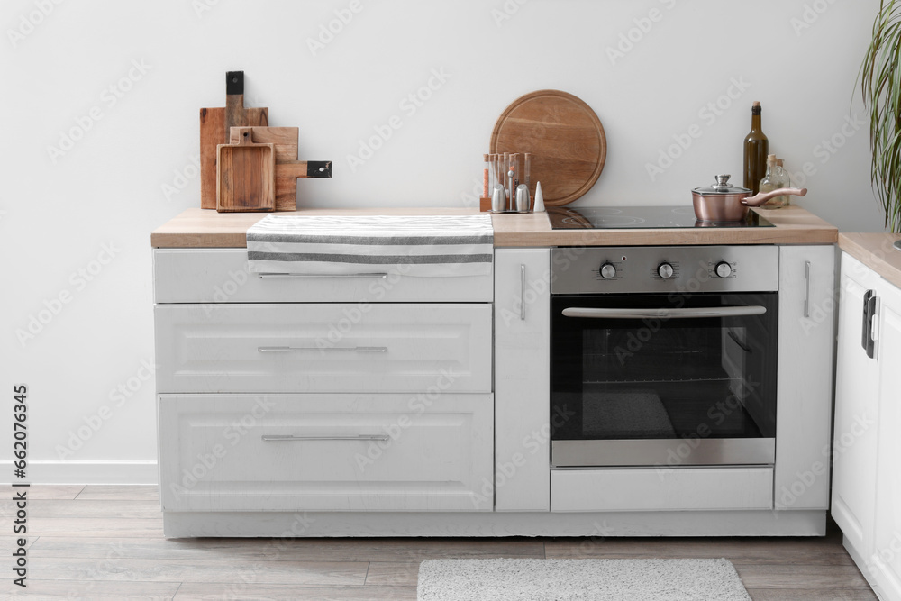 White kitchen counters with cutting boards, electric stove and oven