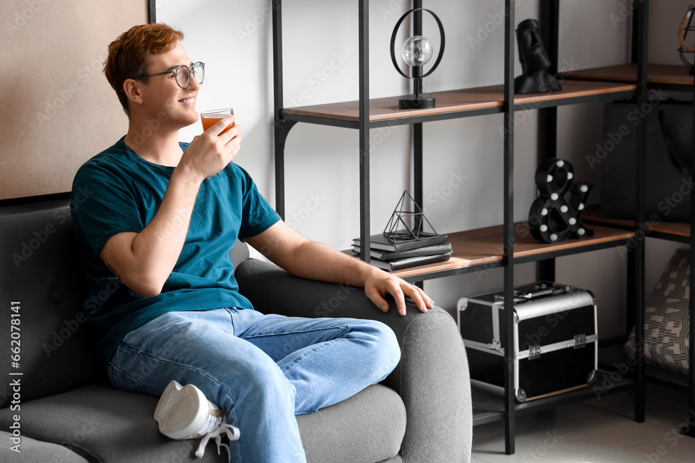 Young man with glass of juice at home