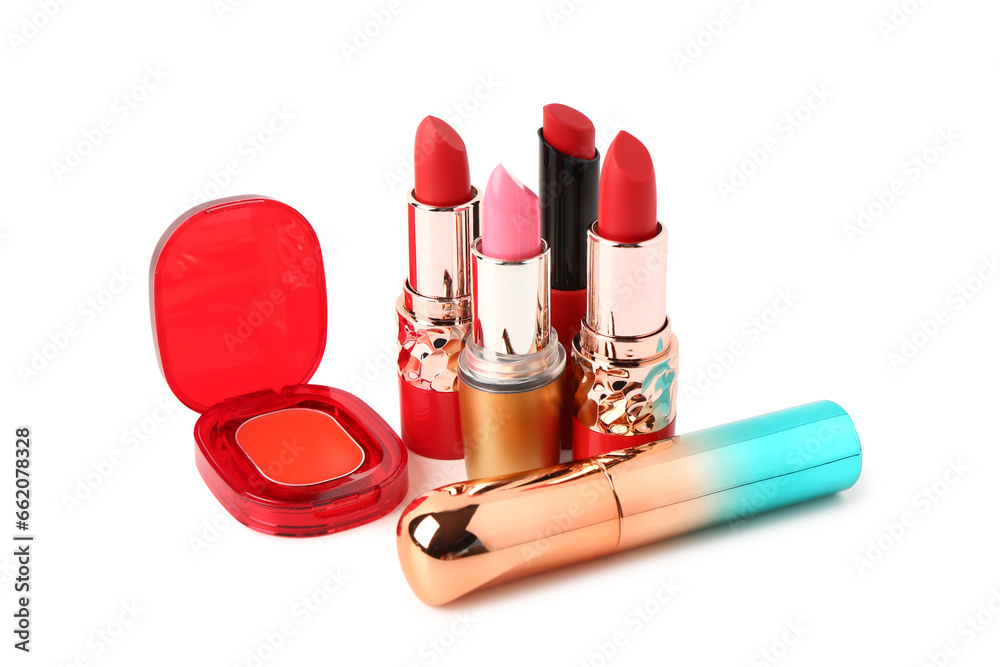 Different lipsticks and mascara on white background