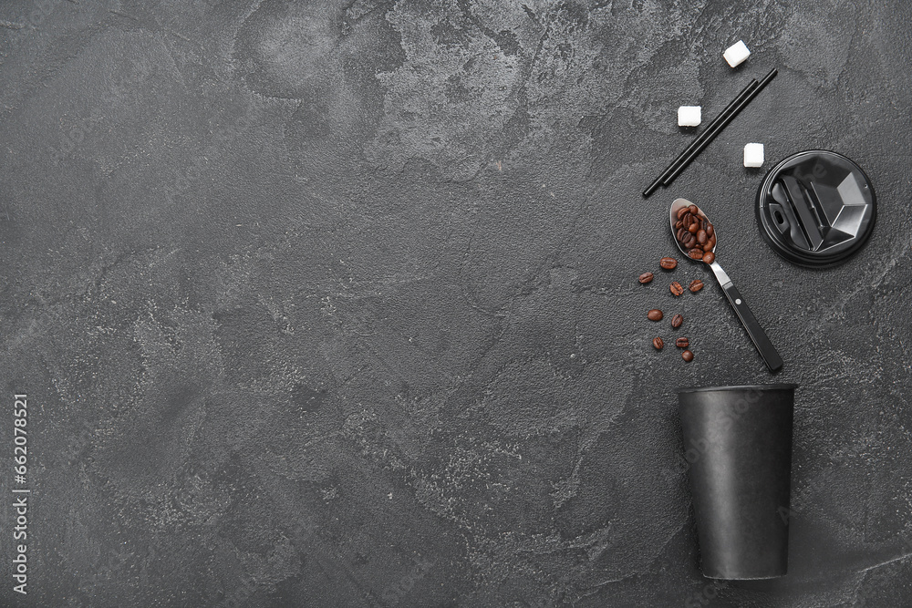 Composition with takeaway paper cup with coffee beans, sugar cubes and straws on black background