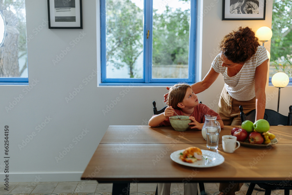 Mother talking to her daughter during breakfast