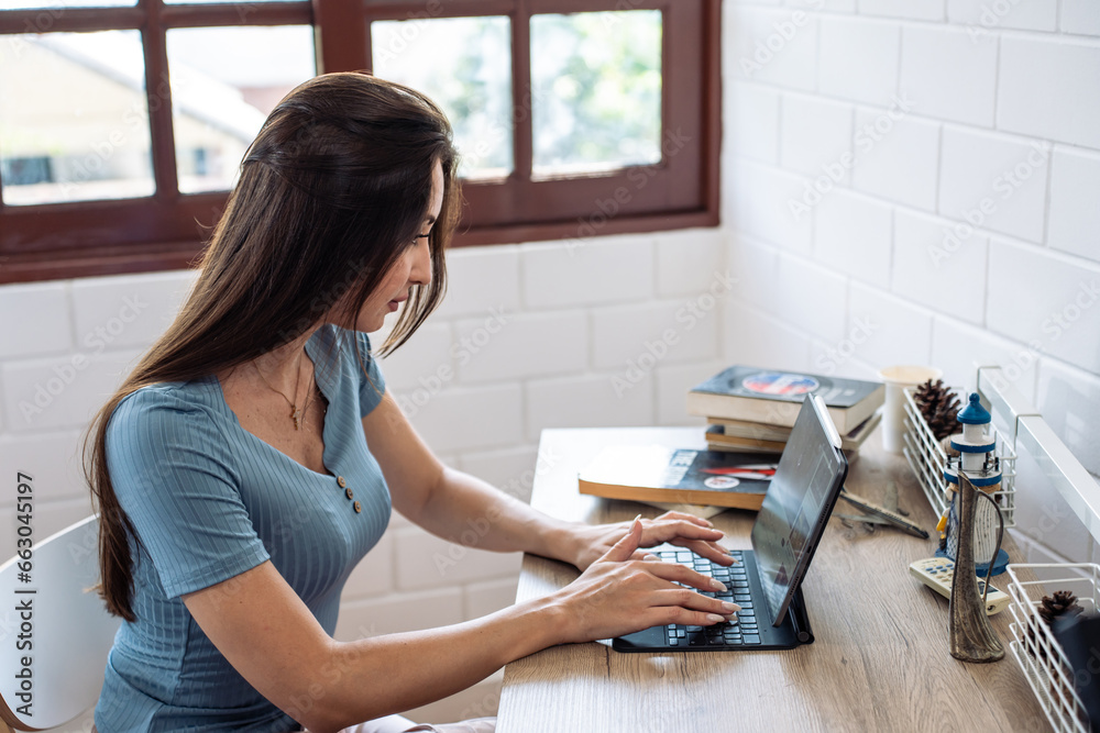 Caucasian businesswoman typing on computer while working from home. 