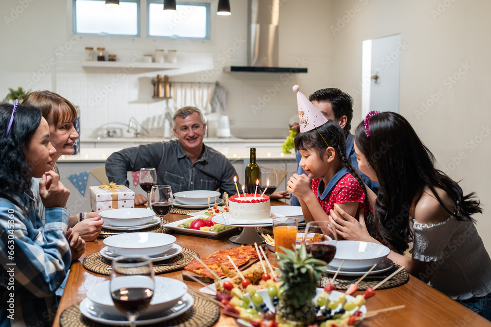 Multi-ethnic big family having a birthday party for young kid daughter. 