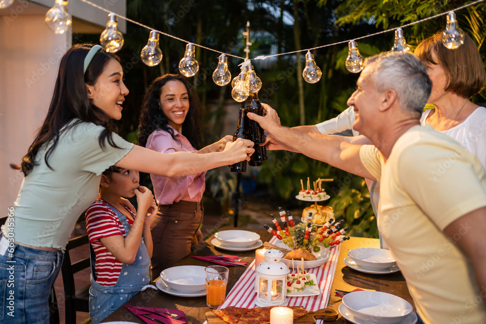 Multi-ethnic big family having fun, enjoy party outdoors in the garden. 