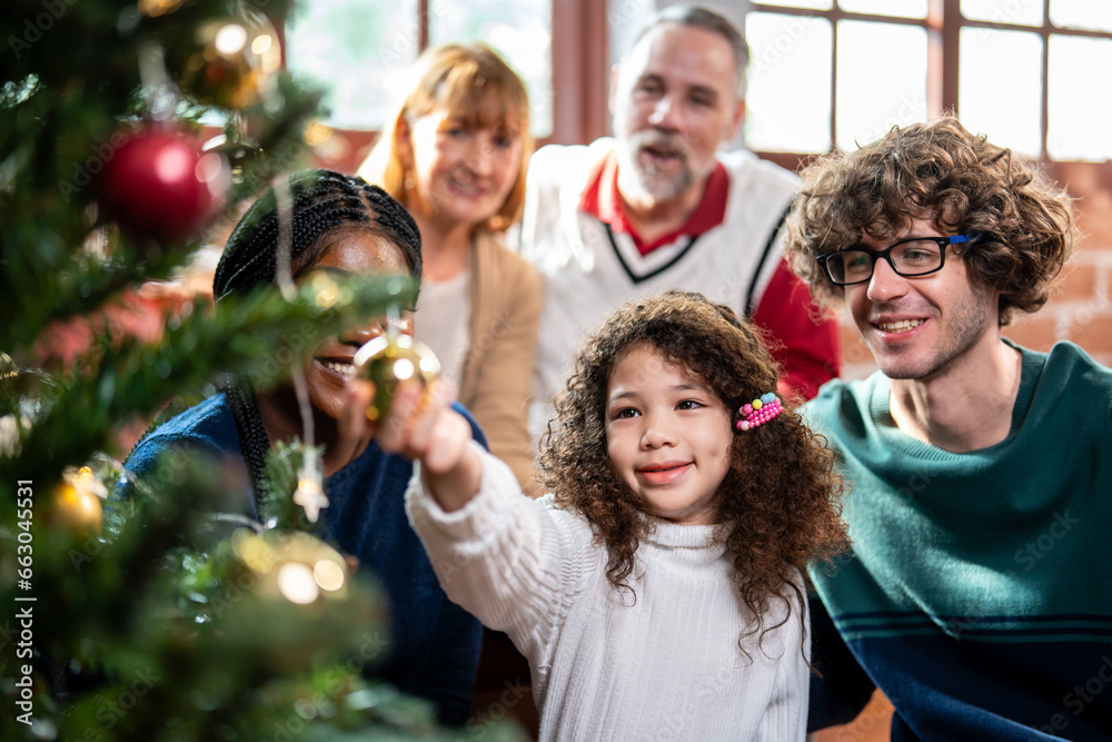 Multi-ethnic big family decorate Christmas tree in living room at home. 