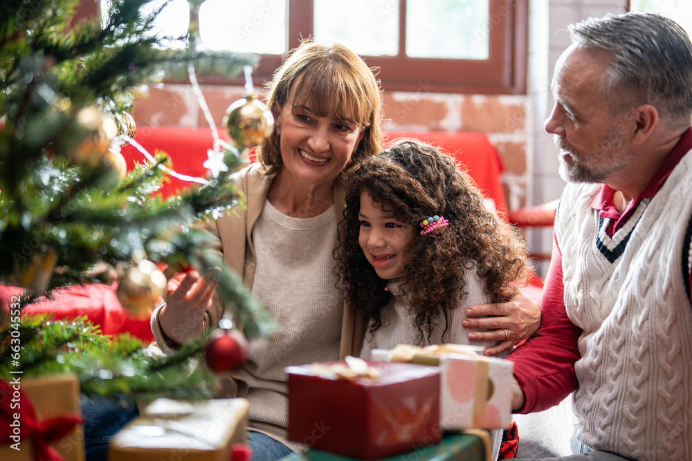 Caucasian family and kid daughter decorating Christmas tree in house. 