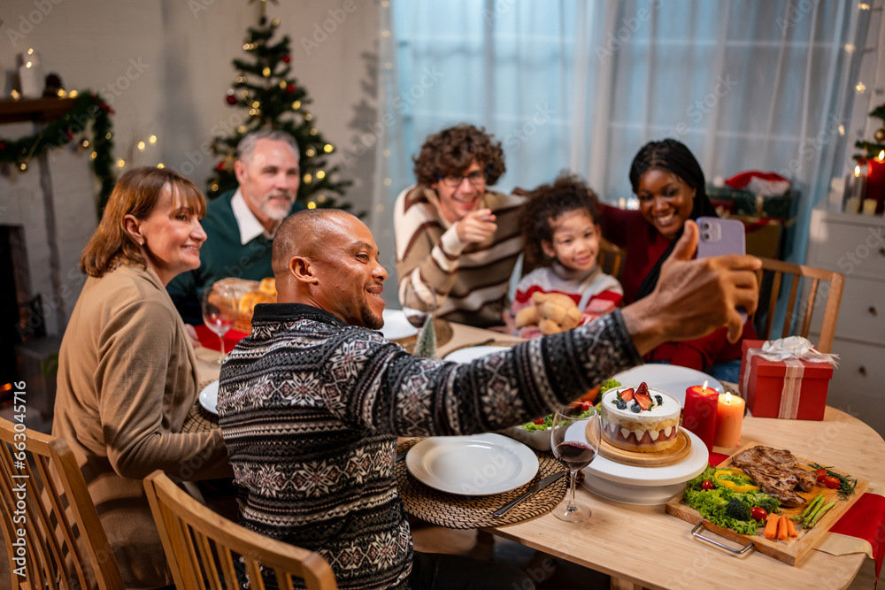 Multi-ethnic family using mobile phone video call online to relative. 