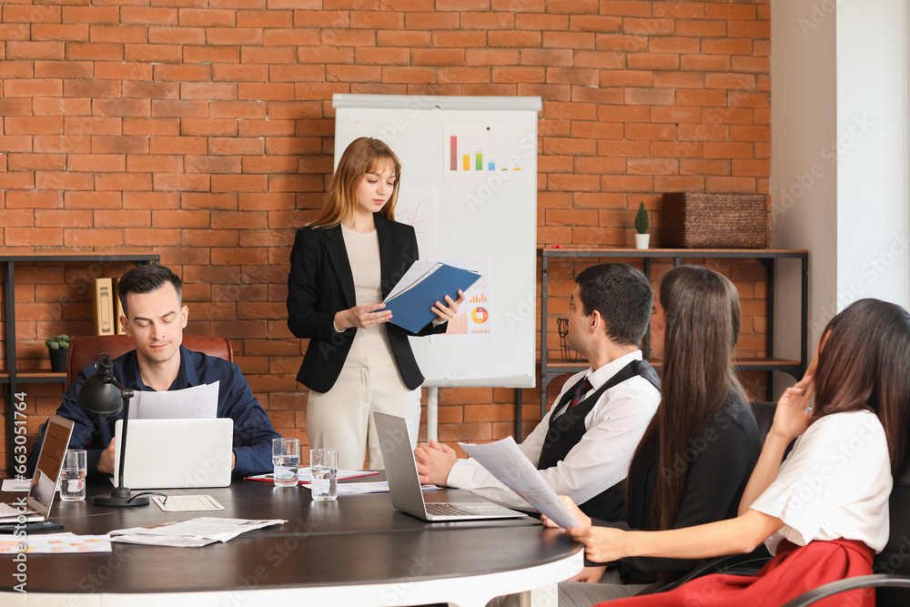 Female business consultant giving presentation to her colleagues in office